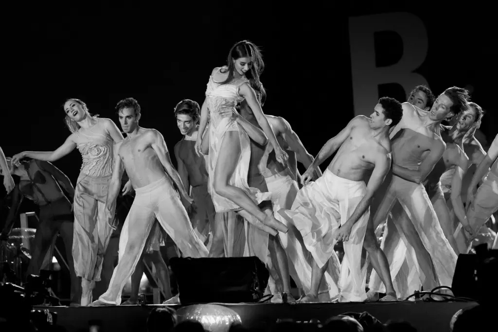 Group of dancers performing in flowing costumes during a choreographed stage show. BattleRoyalStudios