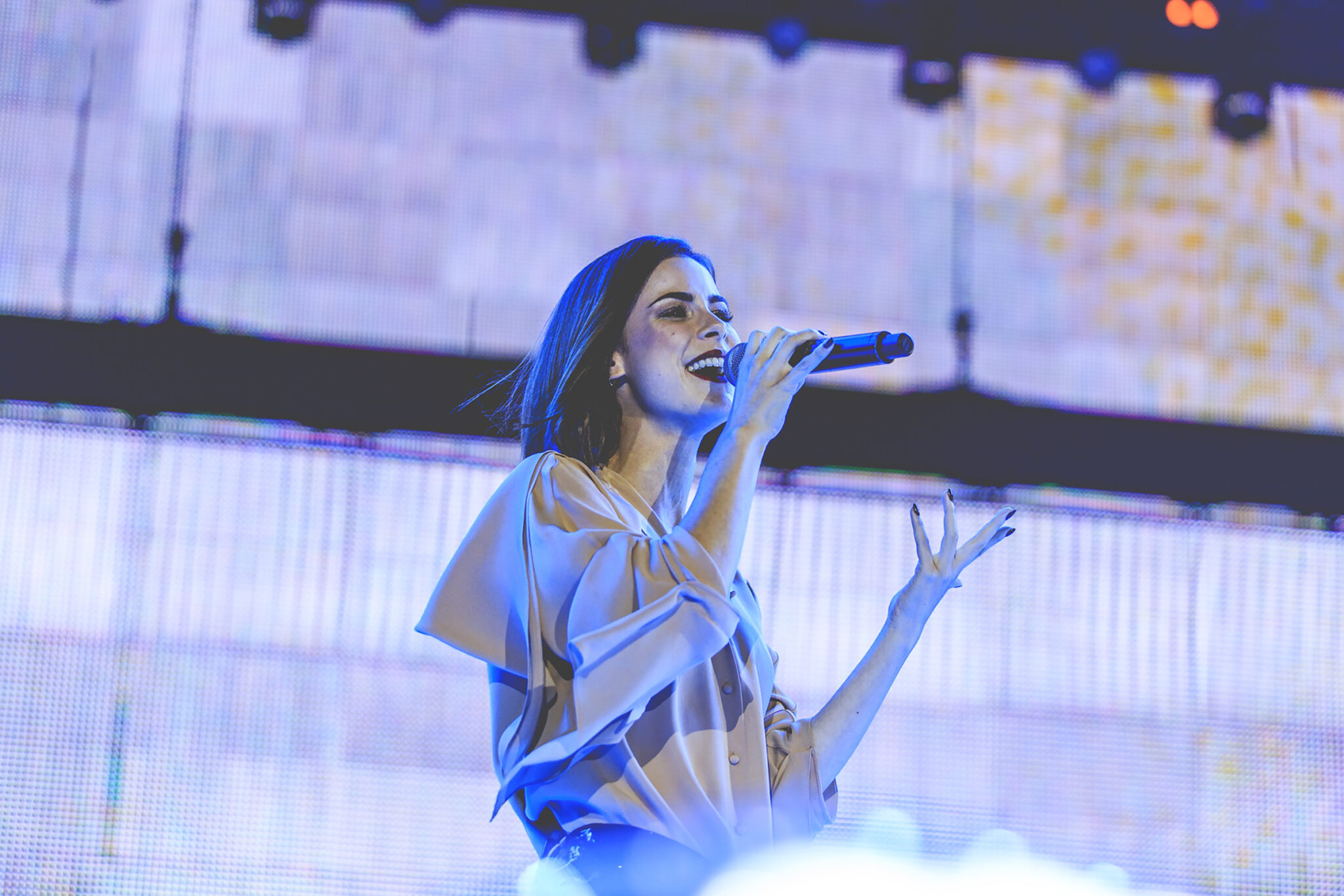Female singer performing on stage with a microphone during a live event at the BMW Festival. Battle Royal Studios