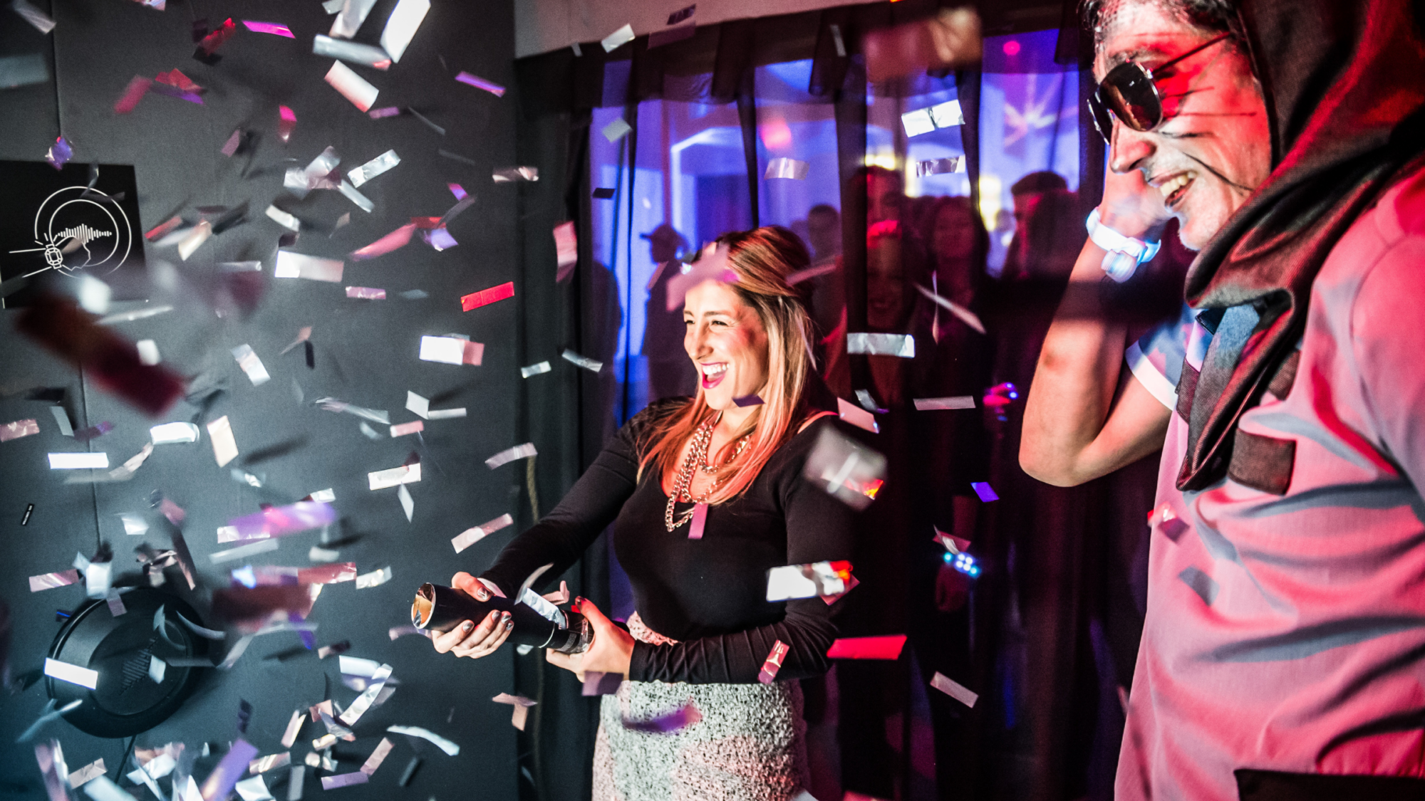 Woman celebrating with a confetti popper while smiling people watch. Battle Royal Studios