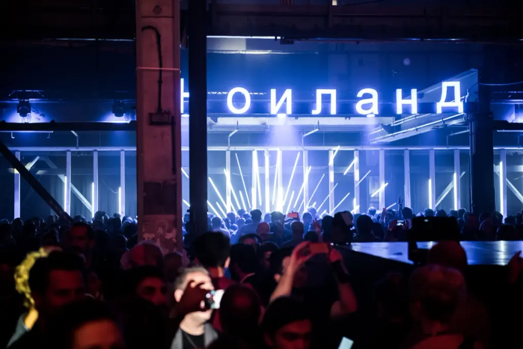 Crowd gathered under neon lights and a bright sign at a Battle Royal Studios event