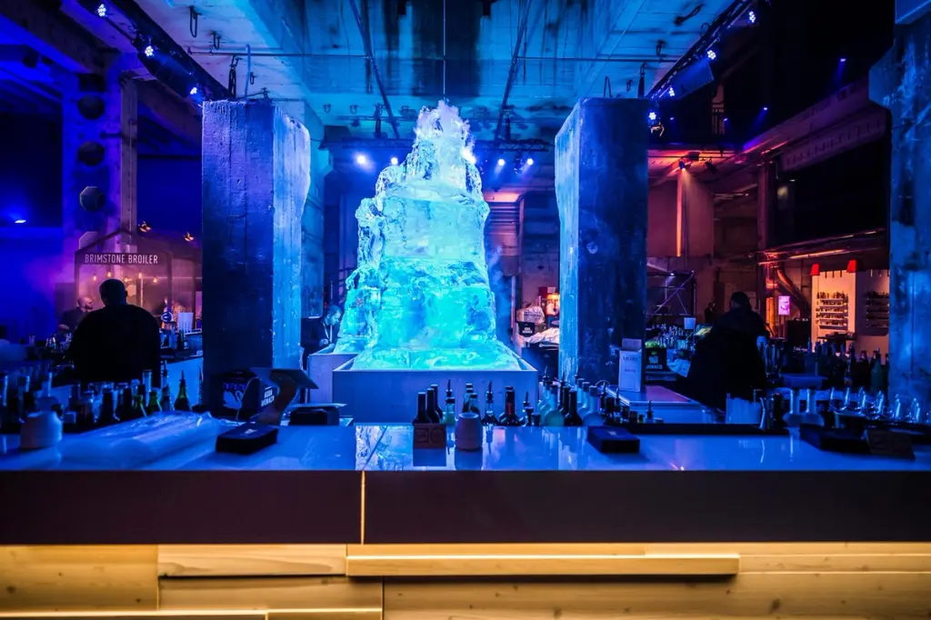 Large ice sculpture illuminated in blue light behind a bar at a Battle Royal Studios event