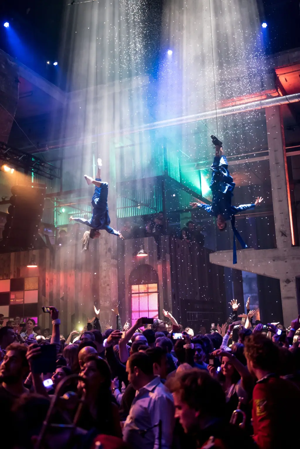 Aerial performers descending from the ceiling with spotlight beams and confetti. Battle Royal Studios