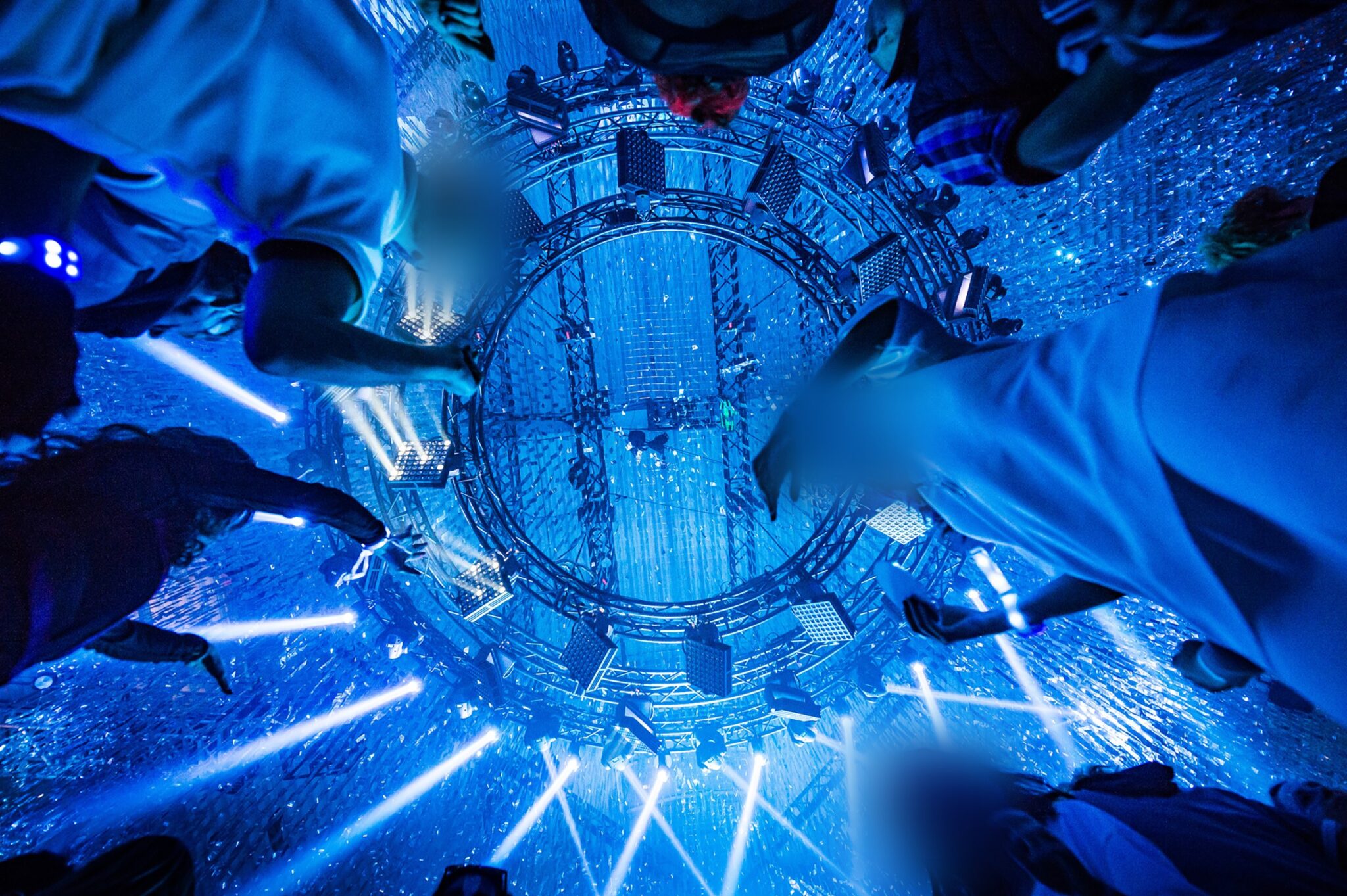 Attendees looking up at a circular stage with dazzling blue lights and visual effects. Battle Royal Studios