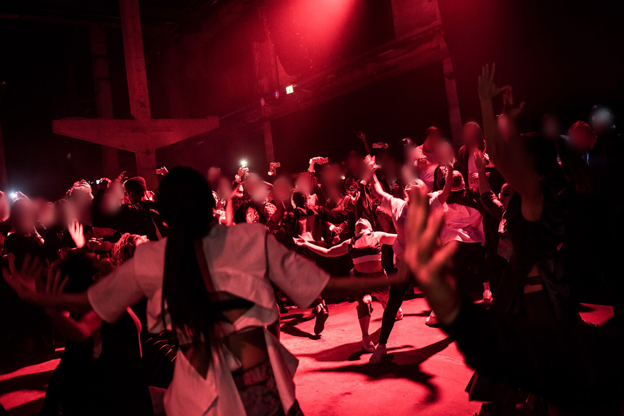 Audience and performers dancing energetically in a red-lit atmosphere. Battle Royal Studios