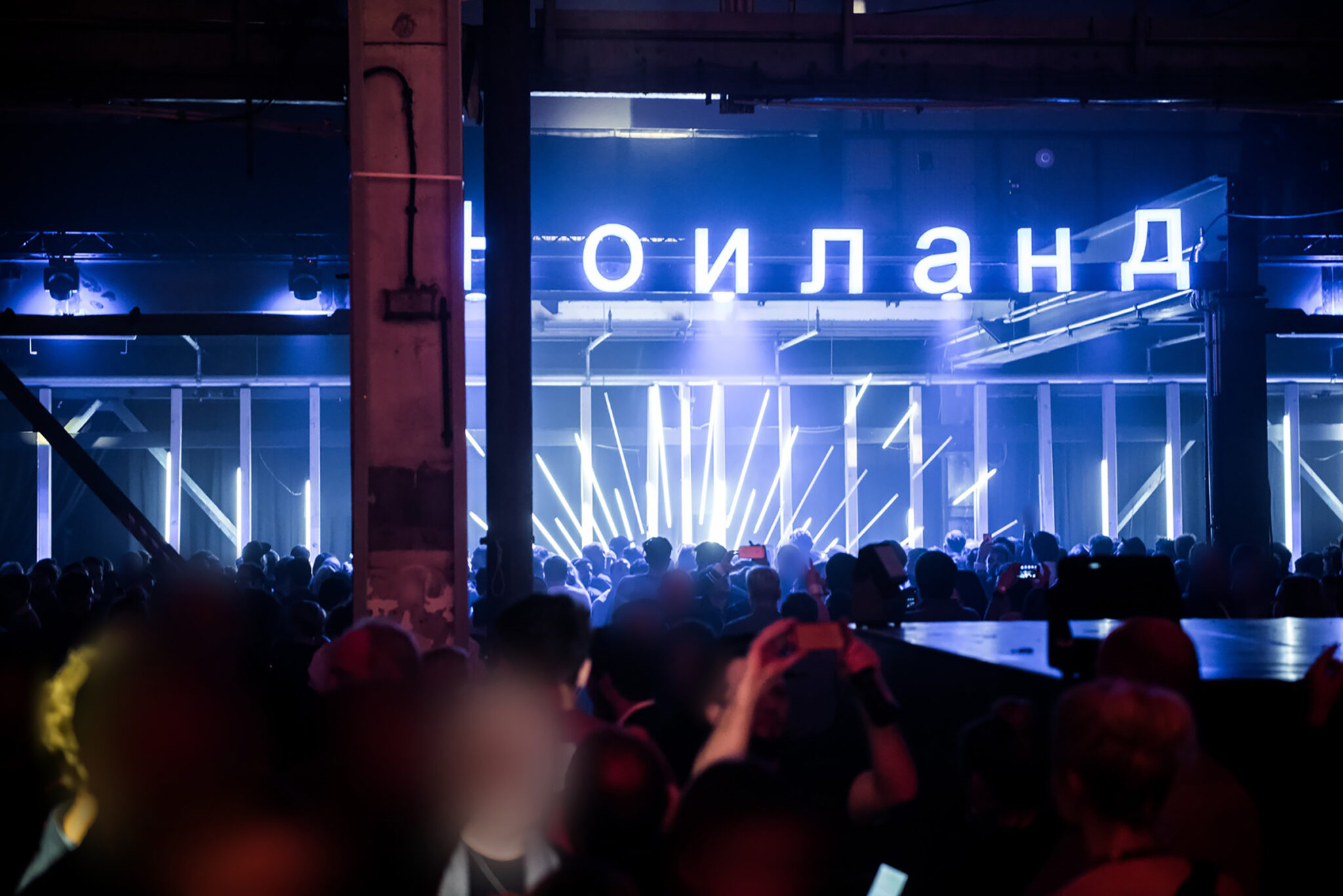 Crowd gathered under neon lights and a bright sign at a Battle Royal Studios event