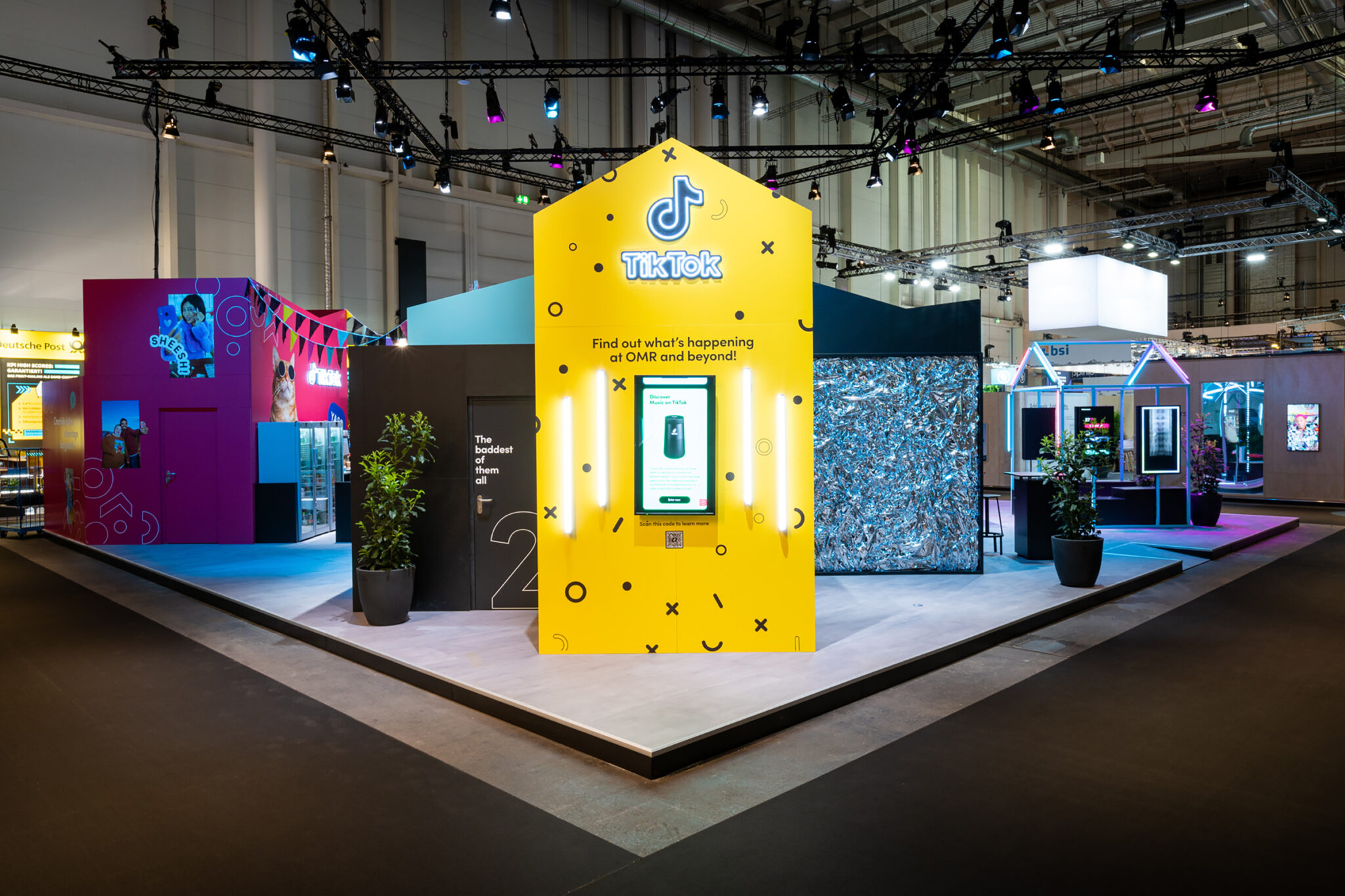 A modern TikTok-themed booth with vibrant lighting, interactive displays, and seating areas, creating a lively atmosphere. Battle Royal Studios