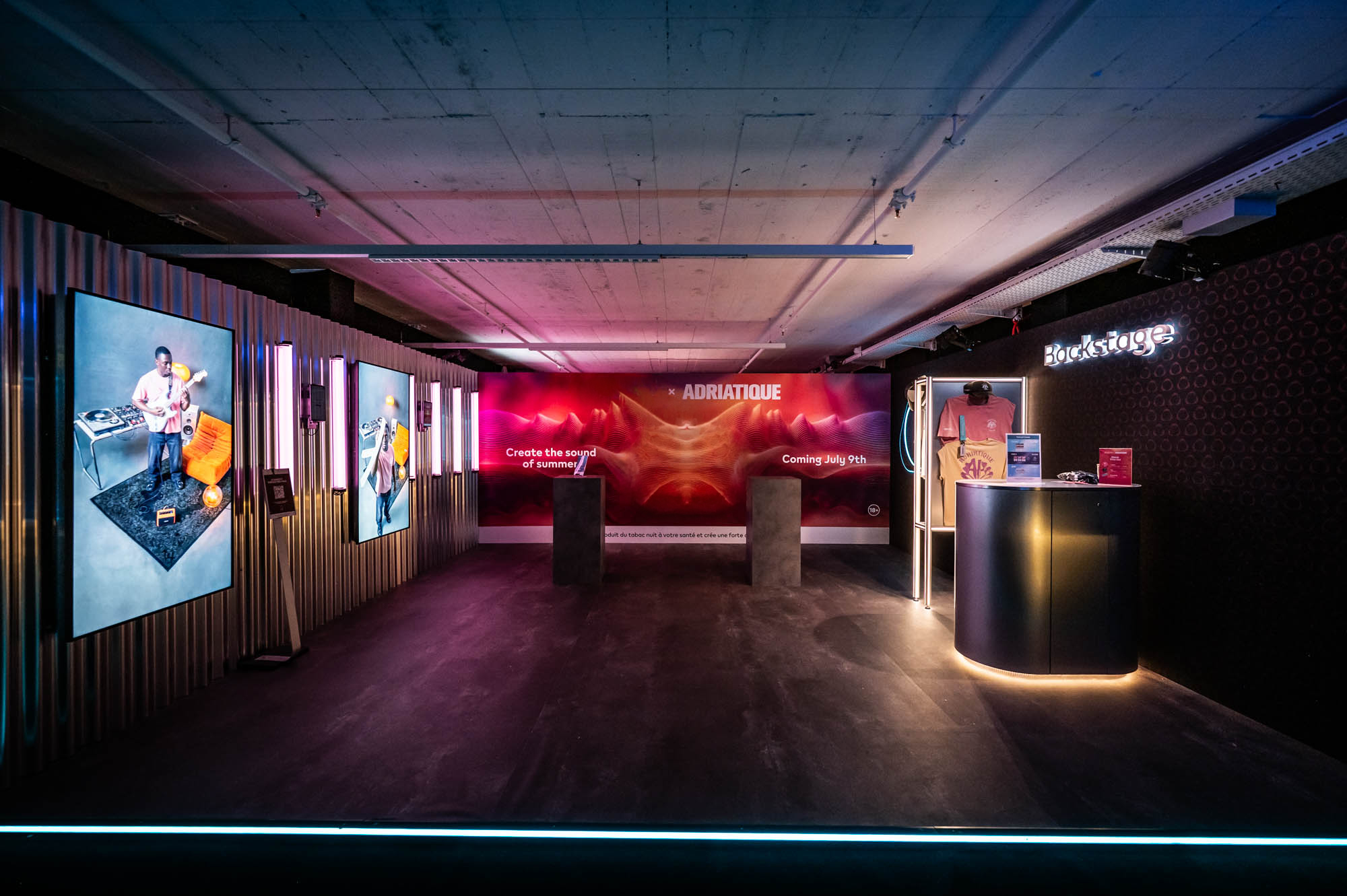 Backstage zone with artwork screens, slatted walls and an illuminated counter.