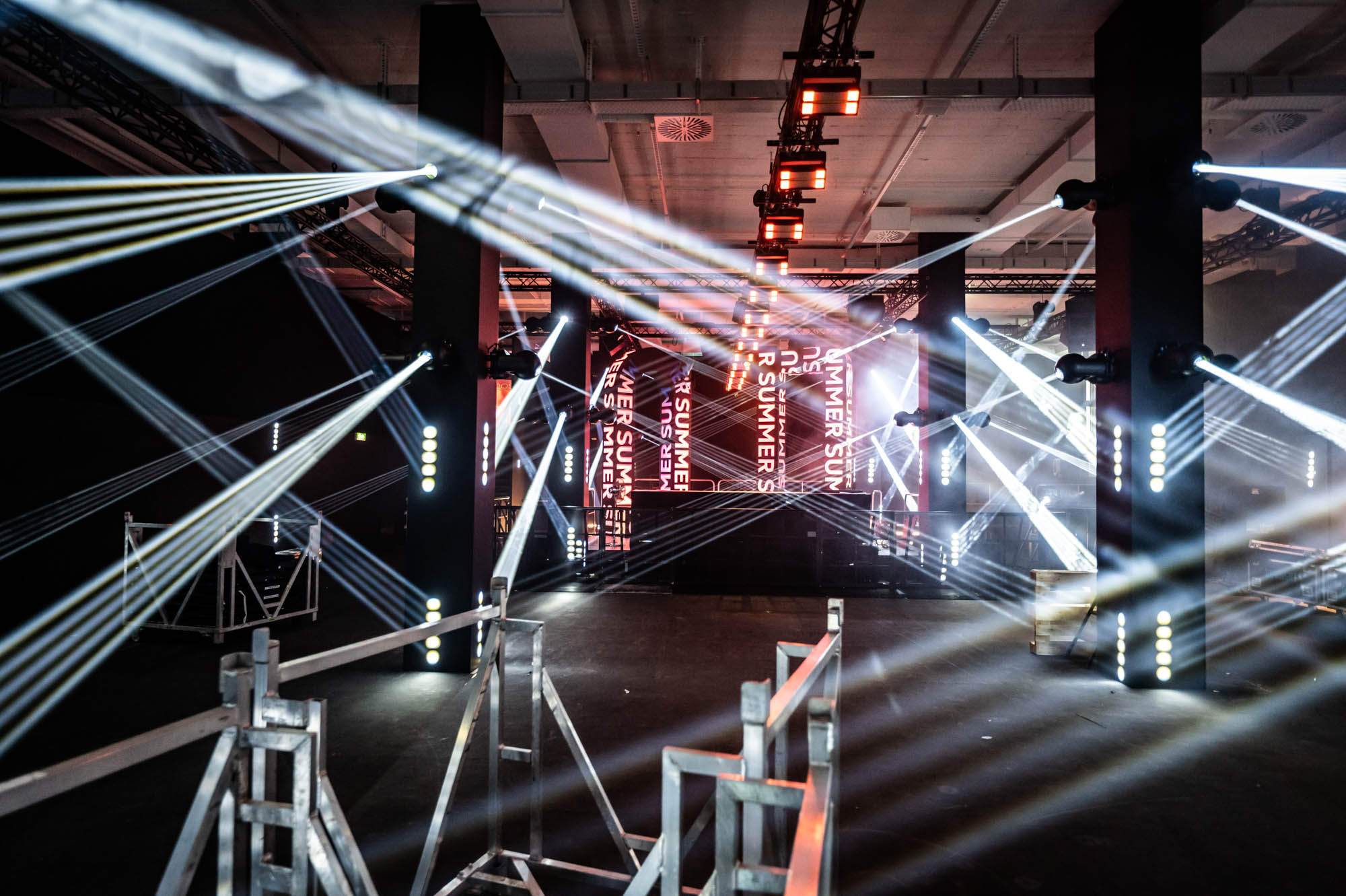 White light beams tested in the main room with scaffolding and equipment in the foreground.